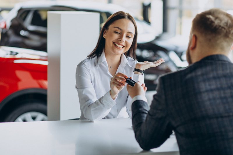 Man with sales woman in car showroom Man with sales woman in car showroom